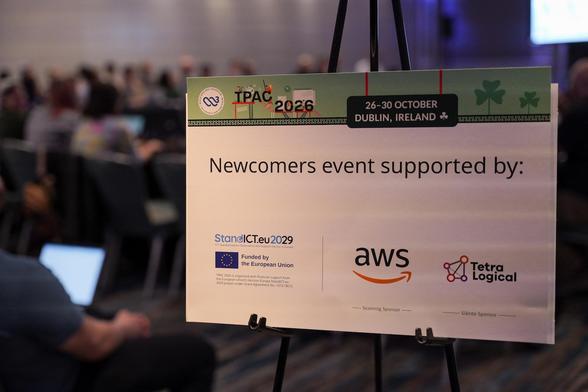 sign with text: "newcomers event supported by StandICt, AWS, Tetralogical"